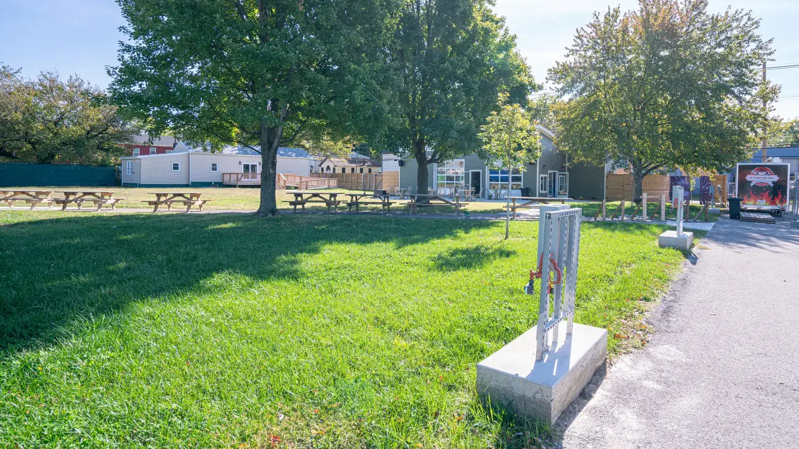 Vendor utility pedestal on a concrete pad along the path at Jubilee Field, with a food truck set up beyond