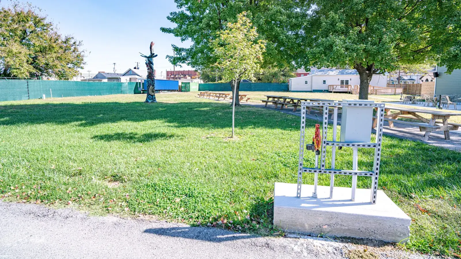 Vendor utility pedestal with its electrical enclosure, mounted on a concrete pad beside the path